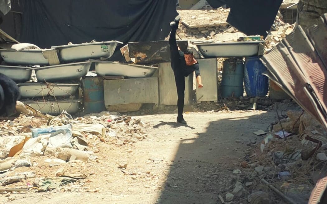 Image of Ahmad dancing among ruins in Damascus