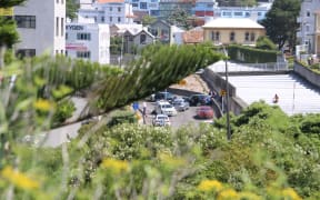 The man sitting on top of the tunnel, with the two-car crash that sparked the incident down below.