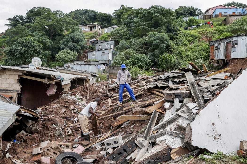 Residents salvage the remains of what use to be the United Methodist Church of South Africa in Clermont, near Durban, on April 13, 2022.