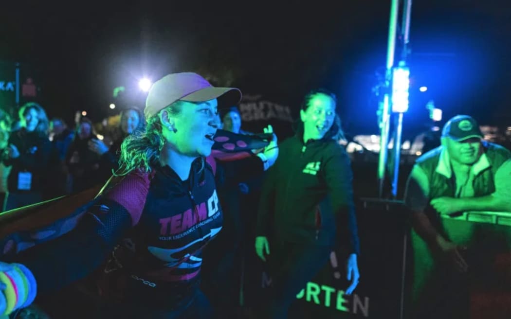 Prue Young finishes the 2022 Ironman NZ wearing a butterfly cape