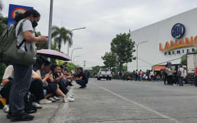 Employees at a shopping mall gather outside the building in Davao City, on the southern island of Mindanao on October 10, 2025, after a 7.4-magnitude earthquake struck off the southern Philippines. A powerful magnitude-7.4 earthquake struck off the southern Philippines on October 10, triggering warnings of a "destructive tsunami" on the country's Pacific coast within hours. (Photo by Bobbie ALOTA / AFP)