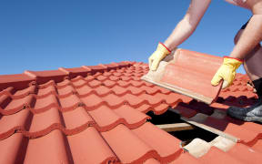 A man fixing a roof.