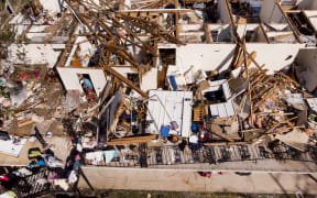 A man works though the remains of an apartment in the aftermath of Hurricane Michael.