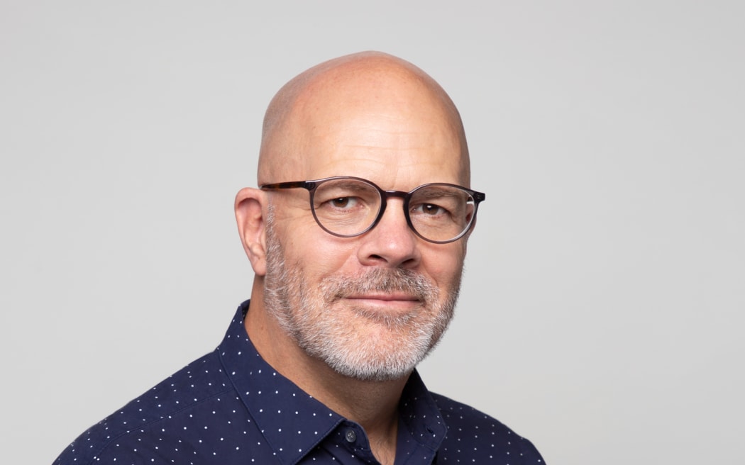 This is an head and shoulders shot of Patrick Dodd. He is bald and wearing glasses and a blue shirt.