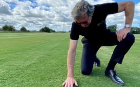 Mark Eman checks out some of the turf grown on his farm.
