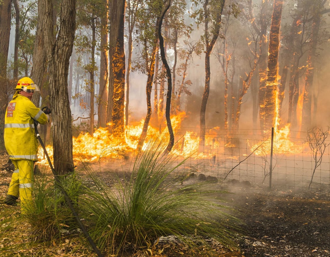 A firefighter battles the blaze  in the Perth Hills.