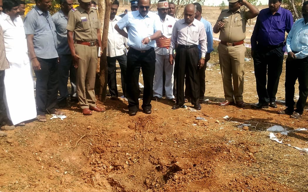 Locals point out the crater at the spot where the meteorite reportedly impacted with the earth