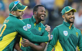 David Miller hugs Andile Phehlukwayo as JP Duminy smiles.