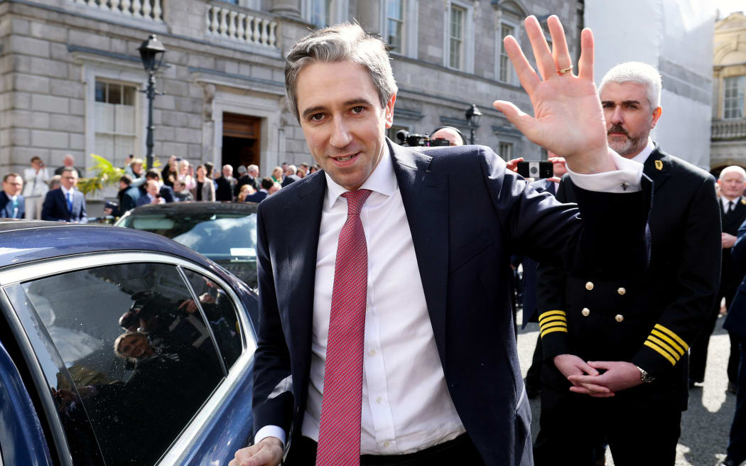 A handout photograph taken on, and released by Ireland's Houses of the Oireachtas on April 9, 2024 shows Fine Gael leader and Ireland's incoming Prime Minster, Simon Harris (C) waving as he he leaves from Leinster House, the seat of the Irish Parliament, after being voted in as Ireland's new Prime Minister. Simon Harris on Tuesday became Ireland's new prime minister, replacing Leo Varadkar after he abruptly quit last month citing personal and political reasons. Ireland's parliament voted 88 to 69 in favour of Harris, 37, becoming "taoiseach" -- a Gaelic word for "chieftain" or "leader" pronounced "tee-shock". (Photo by MAXWELLS / HOUSES OF THE OIREACHTAS / AFP) / RESTRICTED TO EDITORIAL USE - MANDATORY CREDIT "AFP PHOTO / HOUSES OF THE OIREACHTAS / MAXWELLS " - NO MARKETING - NO ADVERTISING CAMPAIGNS - DISTRIBUTED AS A SERVICE TO CLIENTS