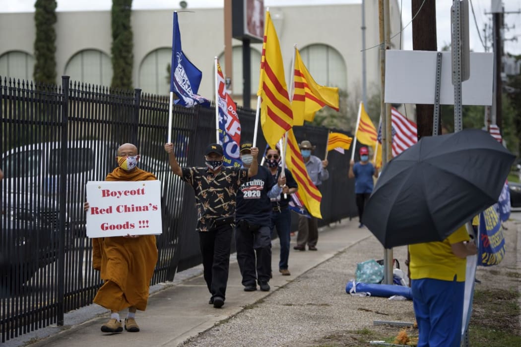 Protesters hold up signs and flags outside of the Chinese consulate in Houston, Texas, on July 24, 2020, after the US State Department ordered China to close it.