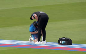 Tim Southee of New Zealand has his injured hand tended to by a physio