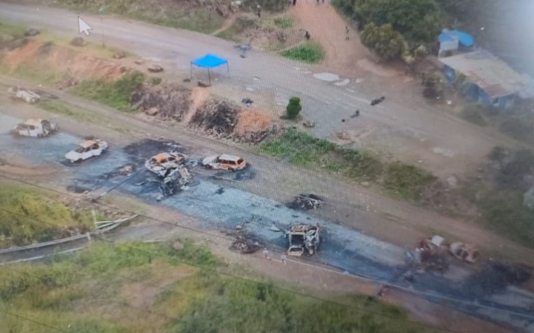 This aerial view shows burnt out vehicles scattered along a highway on the outskirts of Noumea in France's Pacific territory of New Caledonia on May 19, 2024. French forces launched a "major operation" to regain control of a key road linking New Caledonia's capital Noumea to the main international airport, after a sixth night of violent unrest. Officials said more than 600 heavily armed gendarmes were deployed to secure Route Territoriale 1, the main north-south artery connecting the restive capital with the rest of the island and the outside world. (Photo by AFP) / RESTRICTED TO EDITORIAL USE