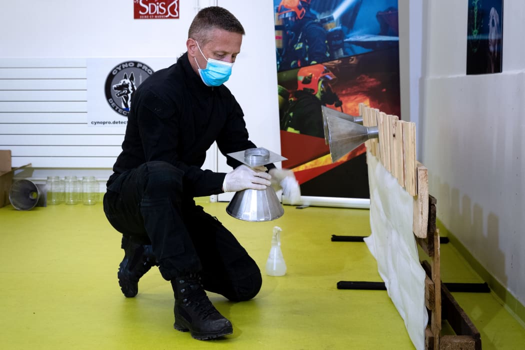 A policeman soaks pieces of fabric with samples of the coronavirus to train dogs to recognise the smell, in Maison-Alfort, on the outskirts of Paris.