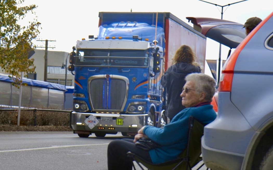 A resident enjoys the parade from her fold-out chair.