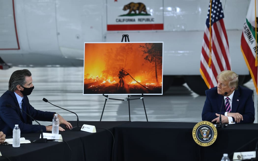 US President Donald Trump(R) speaks to California Governor Gavin Newsom(D-CA) at Sacramento McClellan Airport in McClellan Park, California on September 14, 2020 during a briefing on wildfires.