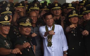 Philippine President Rodrigo Duterte photographed making his trademark raised fist gesture as he meets military officers in Manila, October 2016.