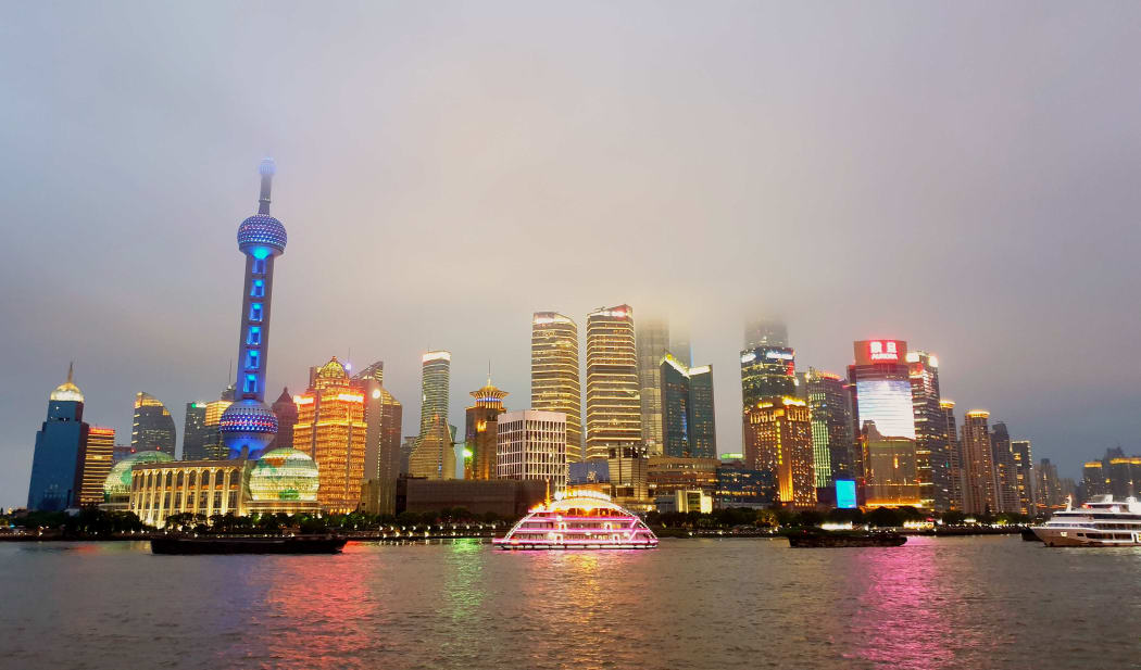 Tall buildings and night time lights of Shanghai from across the water.