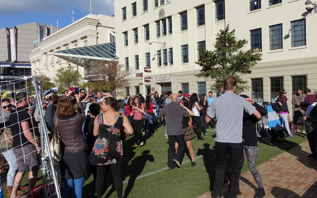 Fans dancing to 'Cumbia Bros' at the "Fever Pitch Fan Hub" in Civic Square