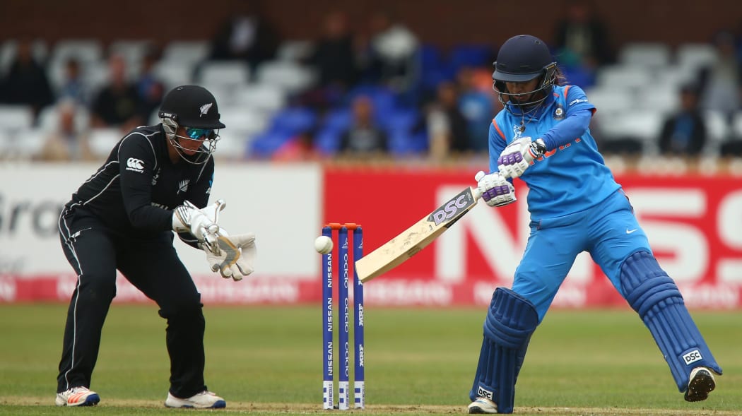 Mithali Raj of India plays a shot off in front of Rachel Priest of New Zealand.