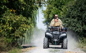 Romanian soldiers ride an ATV down a street in the village of Plauru, Danube Delta, 300 kilometres east of Bucharest, on 12 September, 2023. Romania's defence ministry announced on 12 September, that it has started to set up air-raid shelters for residents in the Plauru area near the Ukraine border after drone fragments were found over the weekend. On 10 September, NATO member Romania said it discovered parts of a drone 'similar to those used by the Russian army' and summoned the Russian embassy's charge d'affaires.