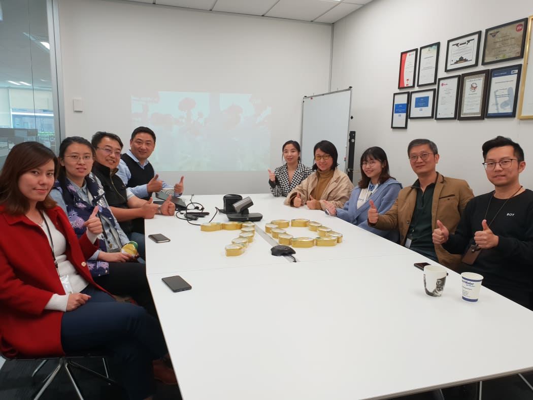 Chinese employees gather in Auckland to live stream China's national day parade.