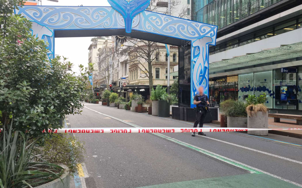 Armed police stand behind a cordon on Auckland's Queen Street following a serious shooting incident in the CBD on 20 July, 2023.