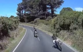 Dashcam footage shows a motorcycle driving over the centre line of a road in front of a truck.