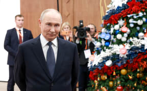 In this pool photograph distributed by the Russian state agency Sputnik, Russia's President Vladimir Putin meets with volunteers during a volunteer organisations forum in Moscow on December 3, 2025. (Photo by Alexander SHCHERBAK / POOL / AFP)