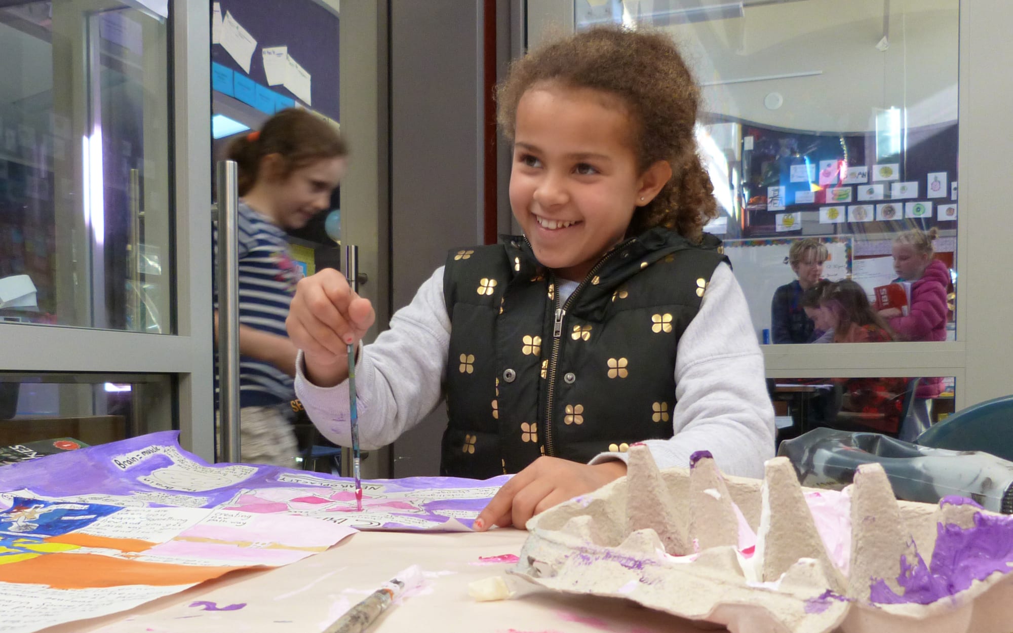 Sienna works on an art project during class