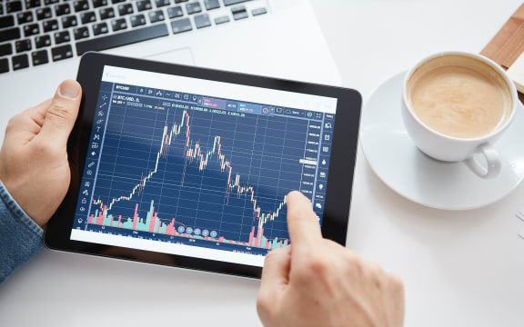 A person looking at stockmarket changes on a tablet.