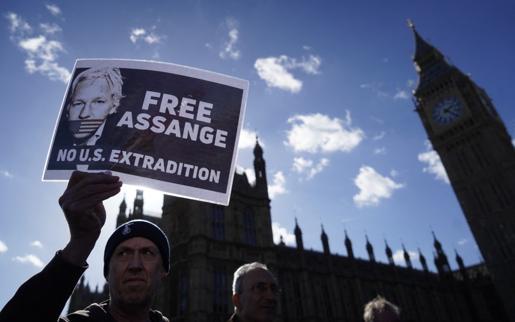 A supporter of WikiLeaks founder Julian Assange holds a placard outside of the Houses of Parliament, in London, on 8 October, 2022, during a demonstration to protest against the detention of Assange.