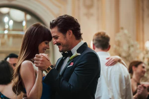 Dakota Johnson and Pedro Pascal smiling and dancing in a scene of Materialists movie.