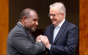 Australia's Prime Minister Anthony Albanese (R) greets Papua New Guinea's Prime Minister James Marape before a signing ceremony at Parliament House in Canberra on October 6, 2025. Australia and Papua New Guinea signed a long-awaited mutual defence treaty, as Canberra seeks to deepen ties with Pacific nations and counter Beijing's rising influence. (Photo by DAVID GRAY / AFP)