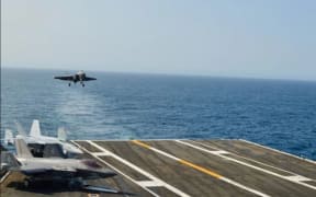 A US F35-C lightning II prepares to land on an aircraft carrier.