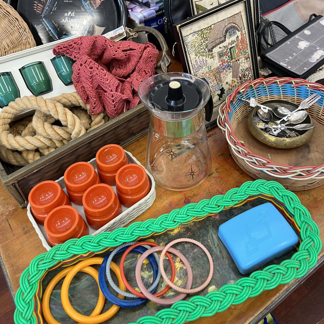 A range of secondhand home goods including books, silver spoons, artwork and a teapot at Gently Loved's flea market.