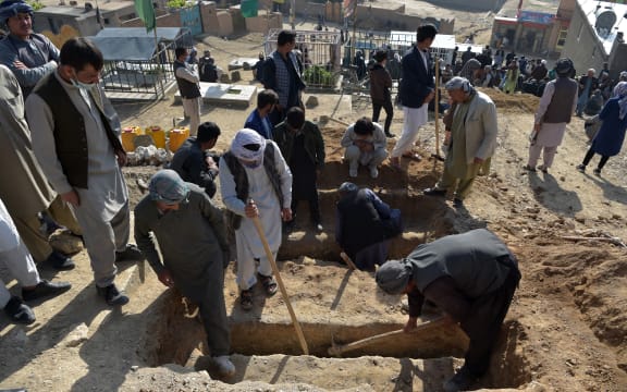 Shiite mourners and relatives dig graves for girls who died in an attack outside a girls' school in Dasht-e-Barchi on the outskirts of Kabul on 9 May, 2021.