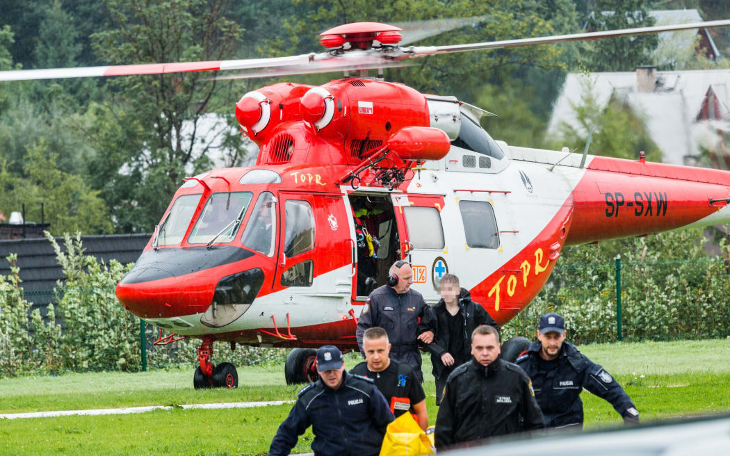 Polish rescue workers move injured tourists from a helicopter near Zakopane, Poland