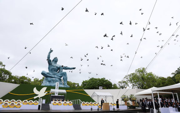 Doves fly past a "Peace Statue" at the Peace Park in Nagasaki after being released during a memorial ceremony on 9 August, 2025, to mark the 80th anniversary of the atomic bombing during WWII.
