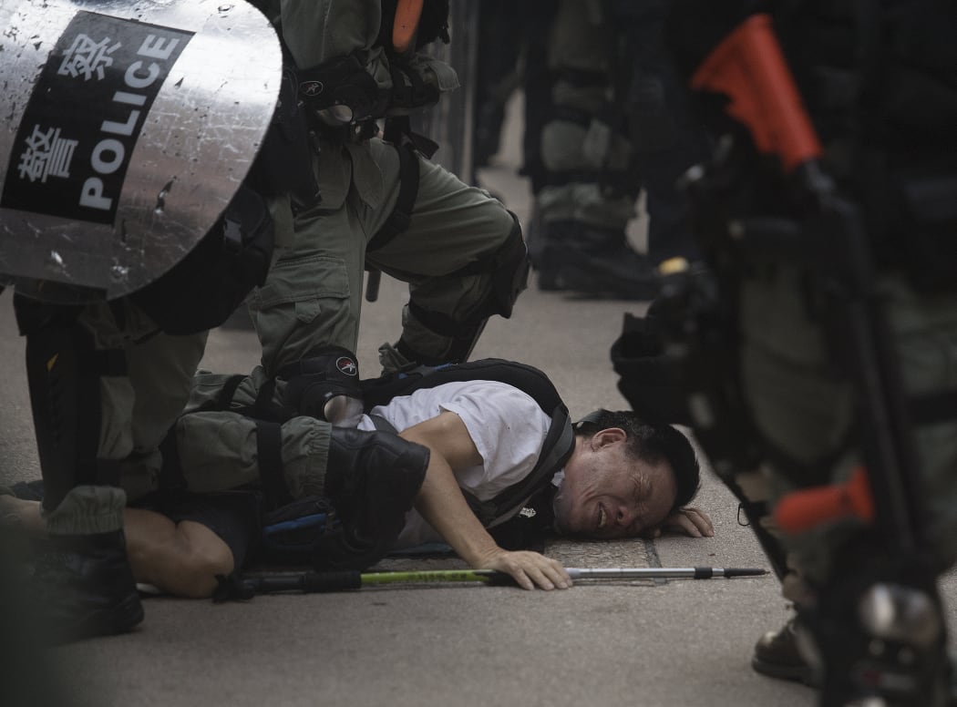 Police arrest a protester in the Wanchai area of Hong Kong as the city observes the National Day holiday to mark the 70th anniversary of communist China's founding.