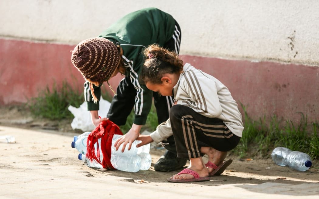 Displaced Palestinian girls are getting water in Deir al-Balah, Gaza, on December 7, 2023, amid continuing battles between Israel and the Palestinian militant group Hamas. (Photo by Majdi Fathi/NurPhoto) (Photo by MAJDI FATHI / NurPhoto / NurPhoto via AFP)