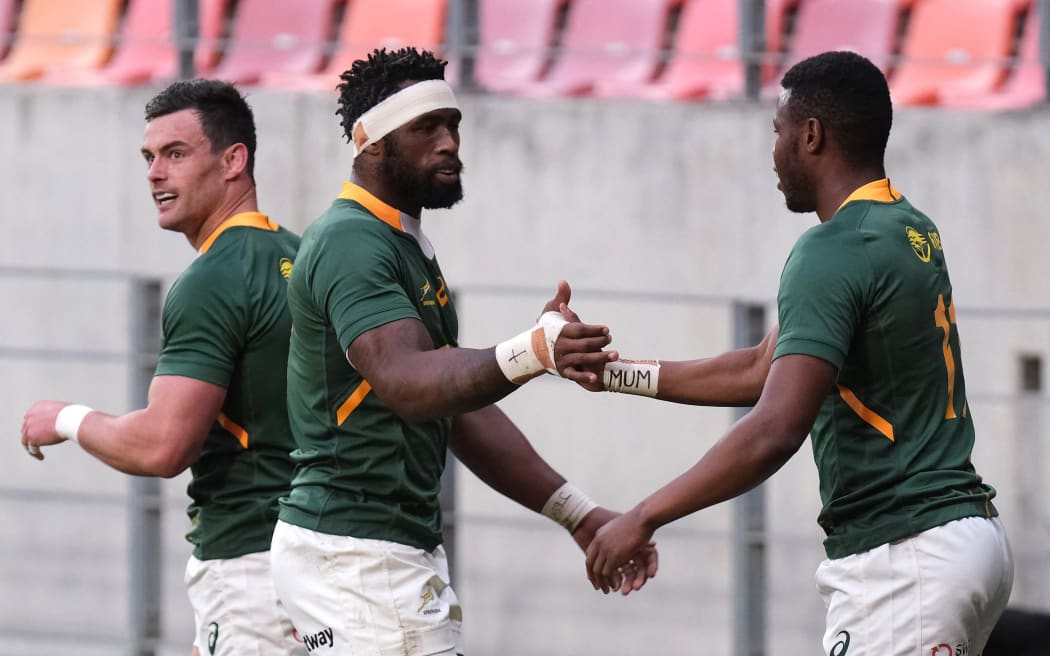 South Africa's blindside flanker and captain Siya Kolisi (C) celebrates with South Africa's wing Aphelele Fassi (R) during the Rugby Championship international rugby union Test match against Argentina at The Nelson Mandela Bay Stadium in Port Elizabeth on August 14, 2021.