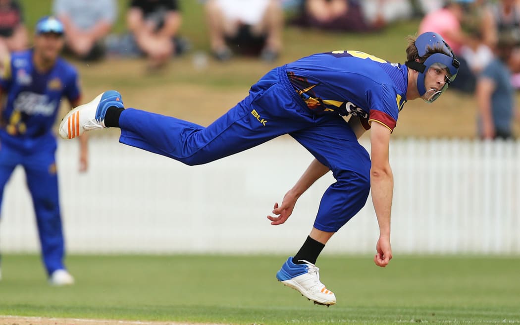 Warren Barnes bowling in his custom-made face mask.