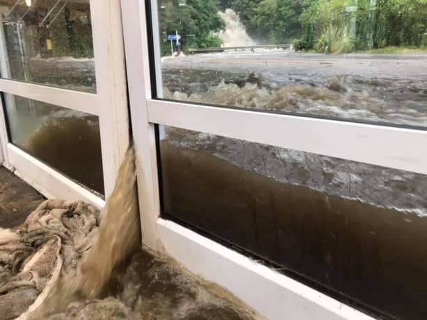 Floodwaters pour into the Milford Visitors’ Terminal on Monday