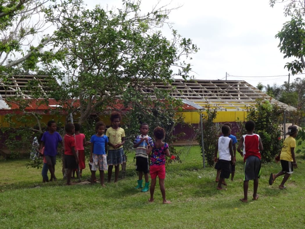 Kids are back at school and playing happily, while their school building is waiting for a new roof.