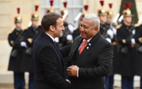 French President Emmanuel Macron (L) greets Prime Minister of Fiji Frank Bainimarama as he arrives at the the One Planet Summit.