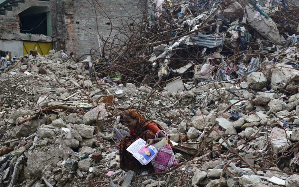 In this file photo taken on August 2, 2013 a mourner grieves for her relative, missing and presumed dead, at the scene of the April 24 Rana Plaza garment building collapse during the one hundredth-day anniversary of the disaster in Savar, on the outskirts of Dhaka.