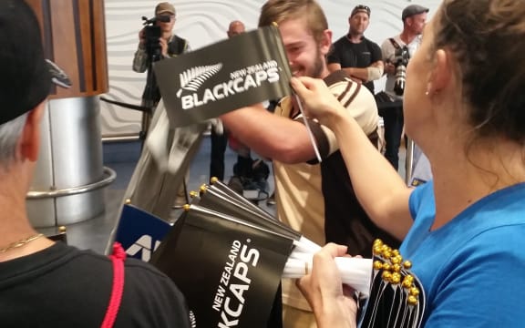Organisers handing out flags to wave when the Black Caps arrive.