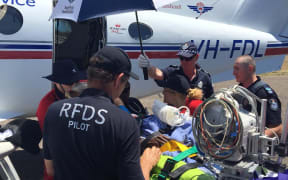 The Flying Doctor service flies out injured victims, after a car was driven into a home where a funeral was taking place in north Queensland.