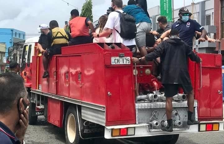 Fijian firefighters give tourists a ride to Nadi Airport amid Cyclone Cody.
