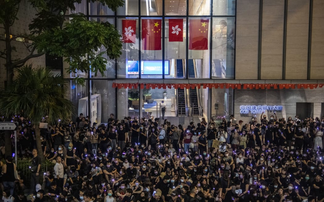 Protester are seen holding up purple lights while standing in front of China and Hong Kong Flags during a rally in Hong Kong on August 28, 2019.